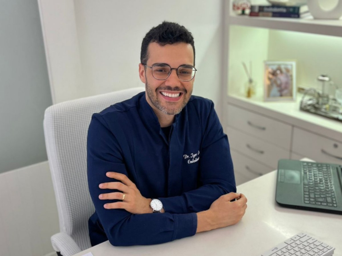 Dr. Igor Leonan de jaleco azul-marinho no consultório em Campos dos Goytacazes-RJ